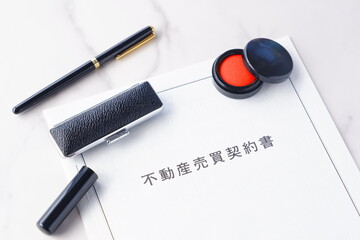 不動産を売買する契約の際に交わす不動産売買契約書と印鑑、朱肉で、不動産の売買契約のイメージ
