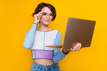 Photo of clever pretty lady arm touch eyewear use wireless laptop isolated on yellow color...