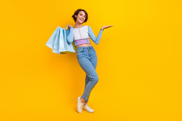 Full length photo of lovely person hold shop bags arm palm demonstrate empty space isolated on...