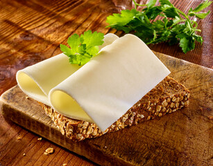Ziegenkaese auf Vollkornbrot und auf rustikalem Fond, belegtes Brot, Käsebrot, Käsescheiben, 