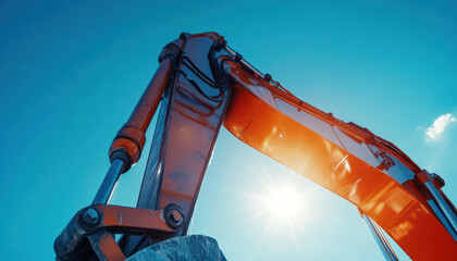 Bright sunlight illuminates a stainless steel tube on an excavator arm, showcasing the details of the machinery in action