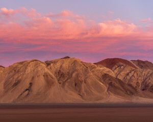 Vibrant sunset over the Atacama Desert mountains near Copiapó, Chile, with pink and purple clouds contrasting the arid landscape
