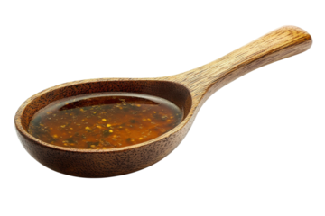 Spoonful of flavorful asian sauce ready to enrich your meal with golden hues isolated on a stark black field