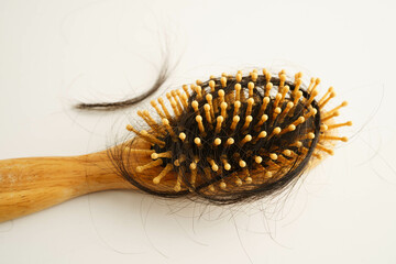 Asian woman have problem with long hair loss attach to comb brush.