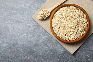 Composition with oatmeal flakes on gray background. Cooking breakfast