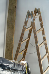 renovation of the house on the staircase and corridor. painting of walls and ceilings. refreshing of the house inside. spreading foil protecting the floor, ladder set up. equipment of the painter.