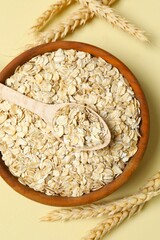Composition with oatmeal flakes on beige background. Cooking breakfast