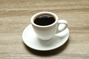 Cuo of coffee with coffee beans on wooden background