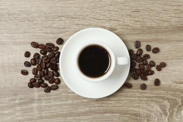 Cuo of coffee with coffee beans on wooden background