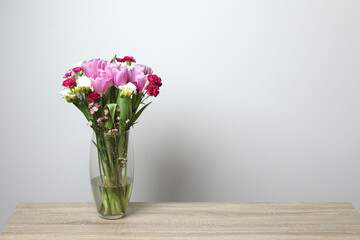 Beautiful bouquet of fresh flowers in the vase on table