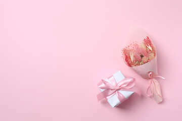 Beautiful bouquet of dry flowers with gift box on a color background