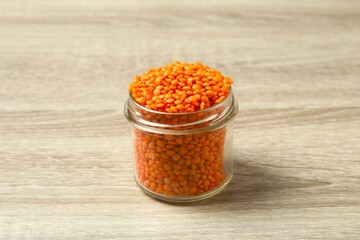 Red lentils in a jar on a wooden background