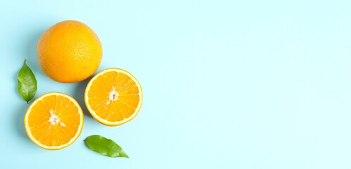 Fresh orange citrus fruit with leaves on blue background