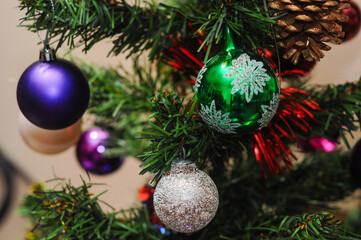 Festive Christmas tree with colorful ornaments and shimmering pine cone