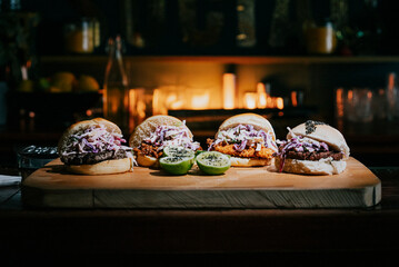 Four different types of sandwiches are displayed on a wooden cutting board