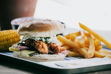 A plate of food with a sandwich, fries, and corn on the cob