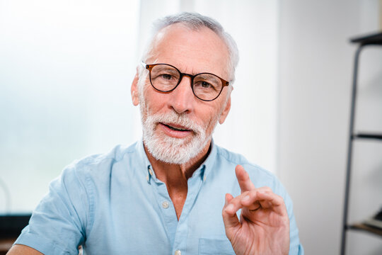 Close up headshot view of smiling mature male employee worker speak on video call in office. Portrait of senior middle-aged man have webcam digital online talk with client. Virtual event concept.