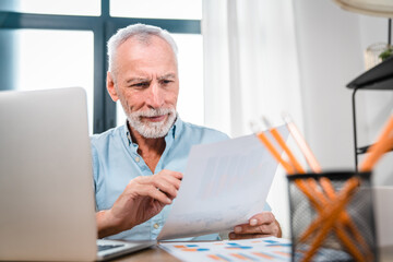 Busy mature professional business man checking documents in office. Middle aged male ceo executive,...