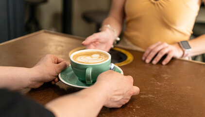 Barista handing a latte to a customer in a cozy cafe