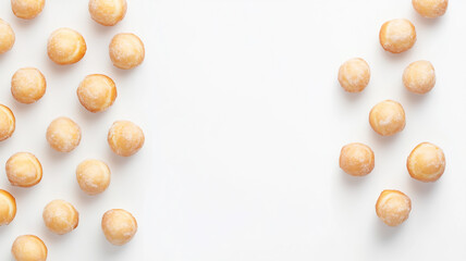 A variety of small, sugar-coated baby donuts arranged on the right side of a white background with plenty of empty space on the left