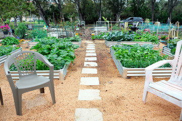 A vegetable garden featuring galvanized metal raised garden beds and wood shaving for mulch, a low...