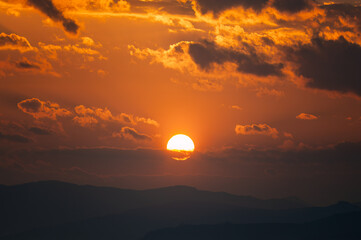 Obraz premium The sun sets over the mountains at dusk