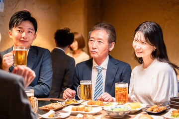 居酒屋で部署のお疲れ様会をするビジネスパーソン