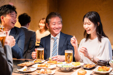 居酒屋で部署のお疲れ様会をするビジネスパーソン