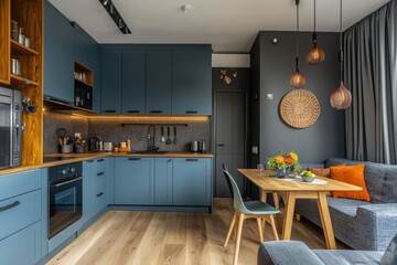 Obraz premium Modern kitchen and dining space featuring blue cabinets and decor