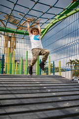 Child playing and climbing on playground equipment having fun outdoors