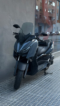Gray Yamaha scooter on textured sidewalk in Spain