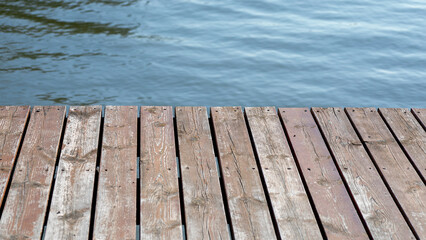 Wooden dock overlooking rippling water, serene outdoor nature scene, summer relaxation, coastal tranquility