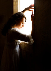 A young woman is gazing out of the window.
