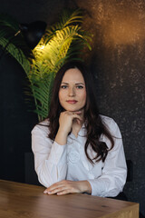 Portrait of a beautiful woman sitting at the table. Business concept