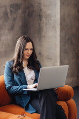 Confident Businesswoman Working on Laptop in a Modern Office Space