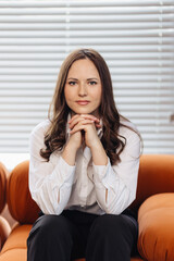 Portrait of a businesslike and elegant businesswoman sitting and looking at the camera
