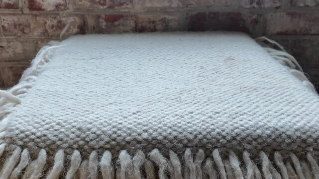 Handmade white sheep wool blanket from natural sheep wool threads. Traditional hand weaving products