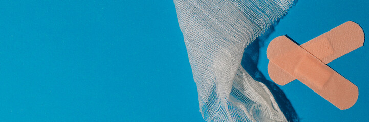 Band-aids and medical gauze on blue background, healthcare, first aid, injury care, medical supplies