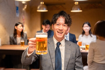 居酒屋でビールの乾杯をするサラリーマンの男性