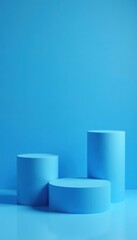 Blue cylindrical platforms of various heights arranged neatly on a blue background for product display,  merchandise,  blue background