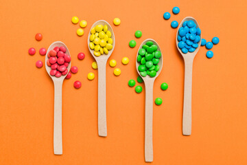delicious colorful sweet candies on spoon on colored background . Confectionery decor top view with copy space