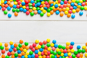 Mixed collection of colorful candy, on colored background. Flat lay, top view. frame of colorful chocolate coated candy