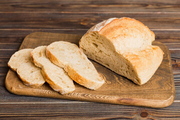 Assortment of freshly sliced baked bread with napkin on rustic table top view. Healthy unleavened bread. French bread slice