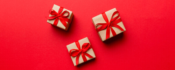 Valentine day composition Background: red gift box with bow and heart. Christmas present. View from...