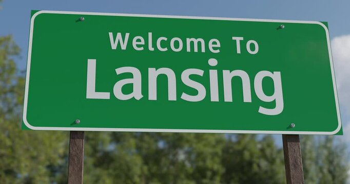 Driving By A Welcome To Lansing, Michigan Green Road Sign Against a Blue Sky and Clouds - United States Capital Series.