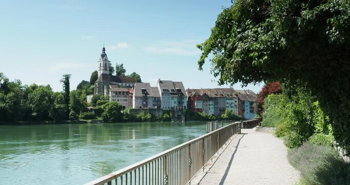 Laufenburg (Aargau) in Switzerland, St. Johan's Church overlooking the historic historic town. View from the terrace of Rhine riverside path along Laufenburg (Baden) in Germany
