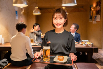 居酒屋のホールで働く若い女性