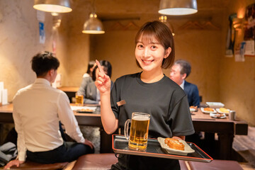 居酒屋のホールで働く若い女性