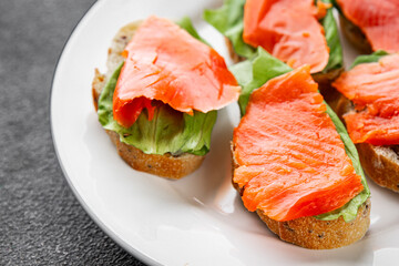 Salmon sandwich red fish seafood appetizer dish fresh tasty gourmet food background on table rustic food top view copy space pescetarian diet