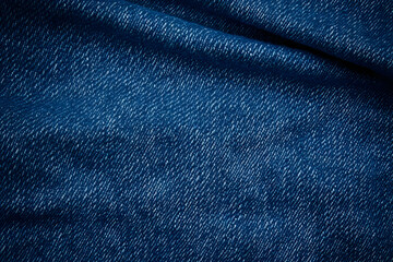 Naklejka premium Close-up view of textured denim fabric showcasing rich blue hues and intricate patterns. Ideal for fashion and textile design.